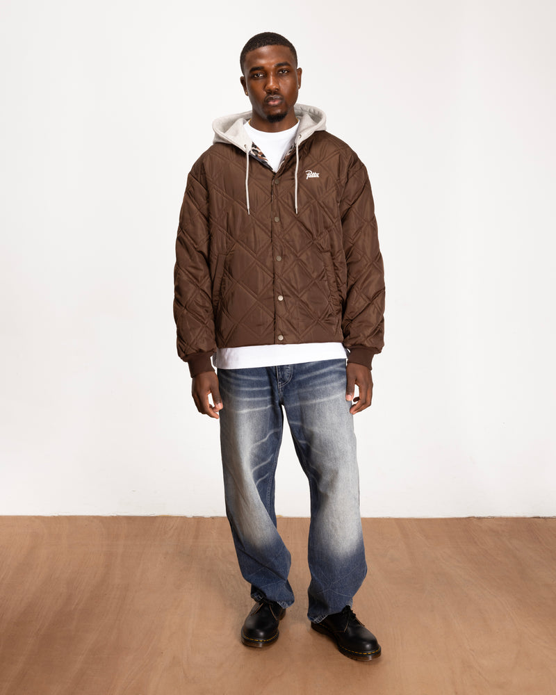 full body model shot of the leopard reversible bomber jacket showing the brown side styled with blue jeans and boots