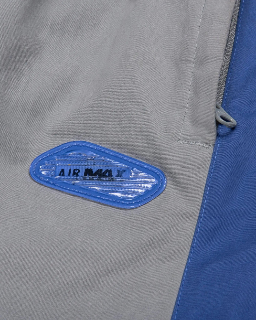 Blue lenticular Air Max badge detail on Patta x Nike NRG Track Pants in Particle Grey.